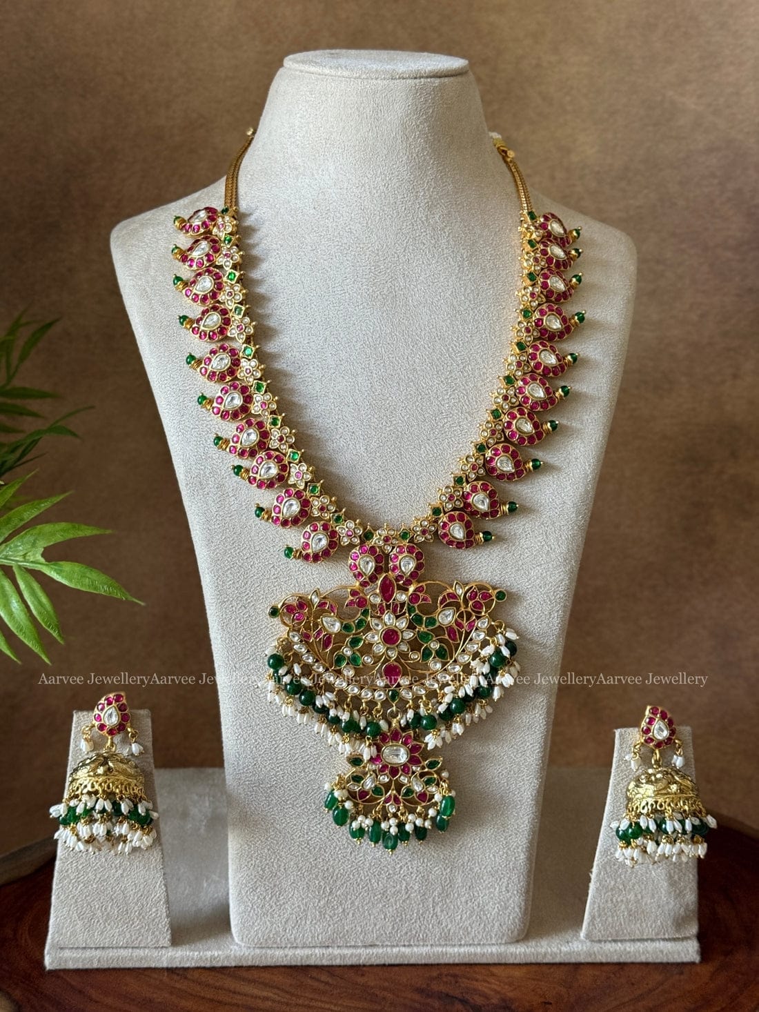 A CLASSIC MANGO MOTIF JADAU KUNDAN HARAM SET WITH LAYERED PENDANT IN GREEN BEADS